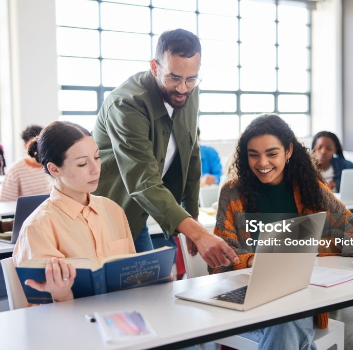 Coach aidant deux étudiantes lors d’un cours