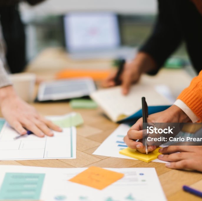 Gros plan sur une table et des mains de personnes analysant les analyse sur papier